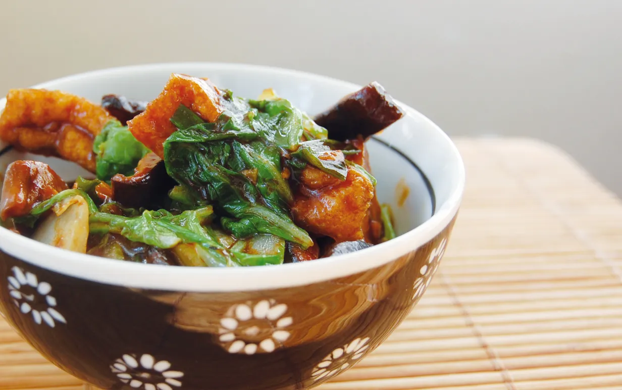 Friterad tofu med kinesisk svamp i en brun skål på ett bord