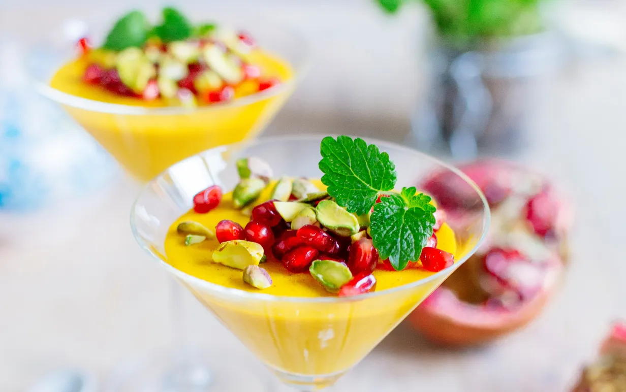 Pannacotta med saffran, toppad med granatäpple, pistagenötter och mynta