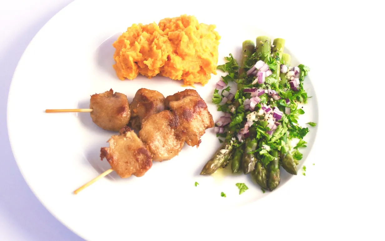 två tzayspett, sötpotatispuré och sparris på ett vitt fat