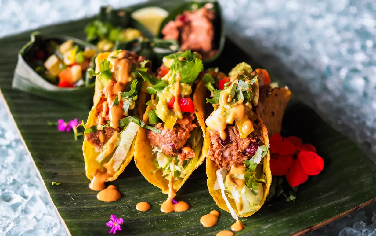 tre jackfruit tacos på en svart bräda