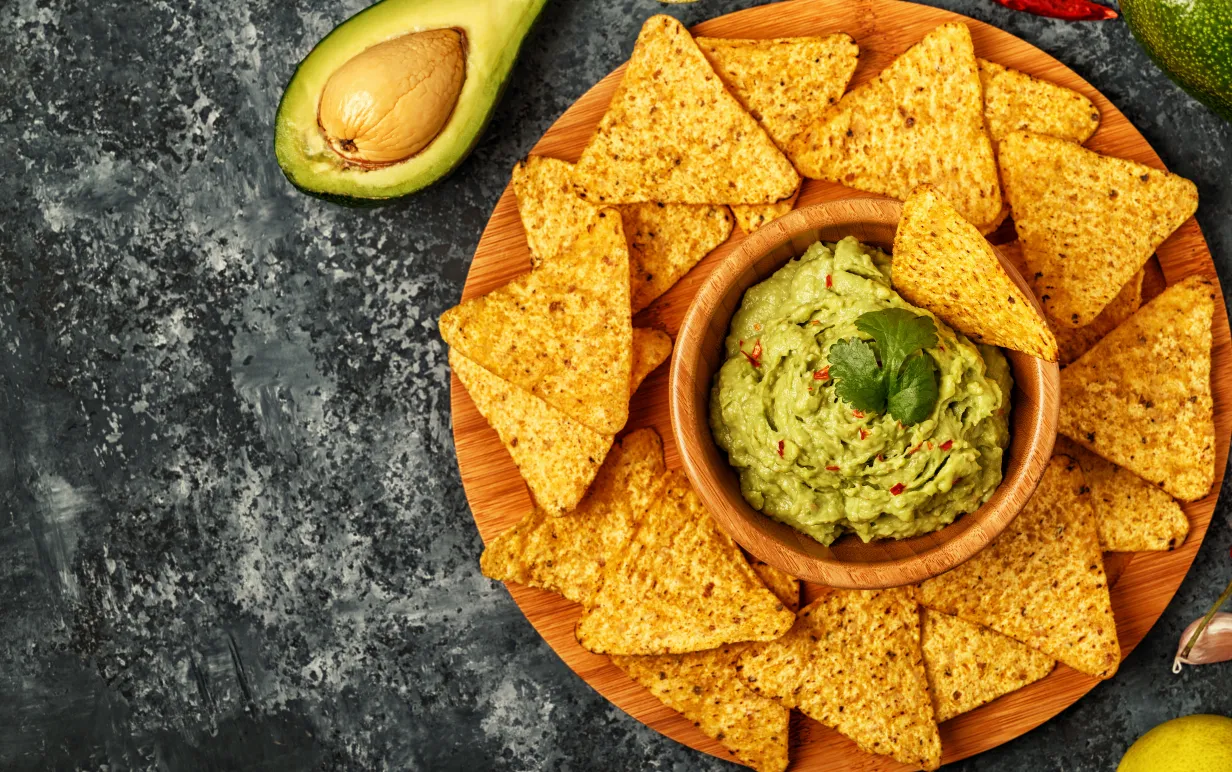 Nachos i en tallrik med guacamole i mitten