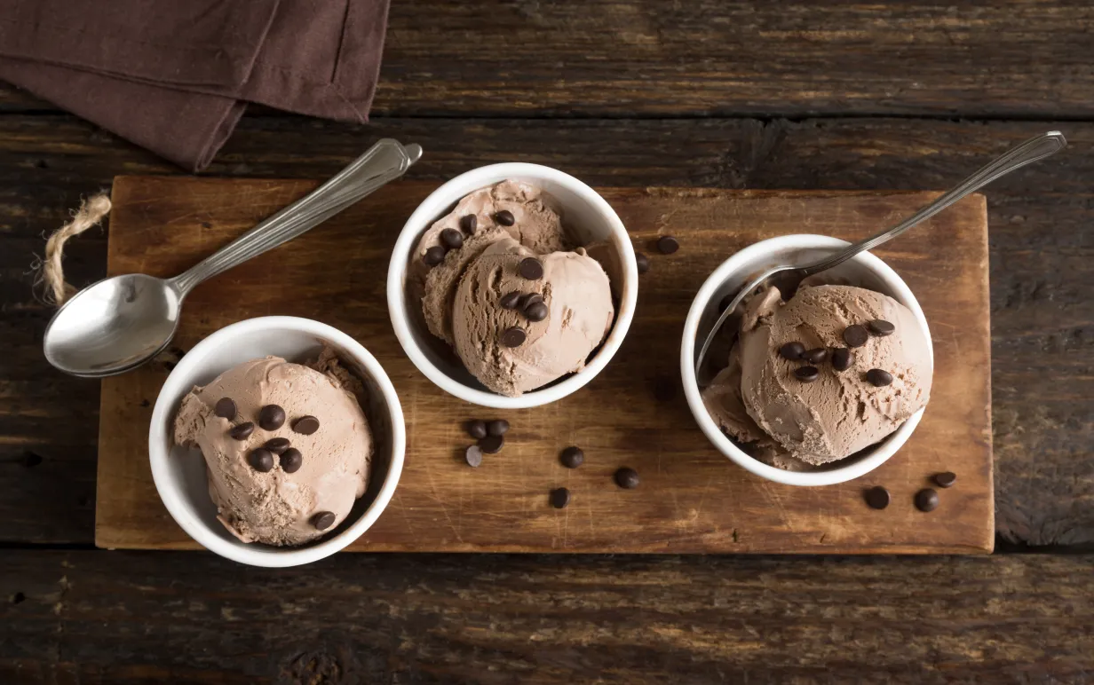 Tre bägare glass med kaffeglass på en träbräda