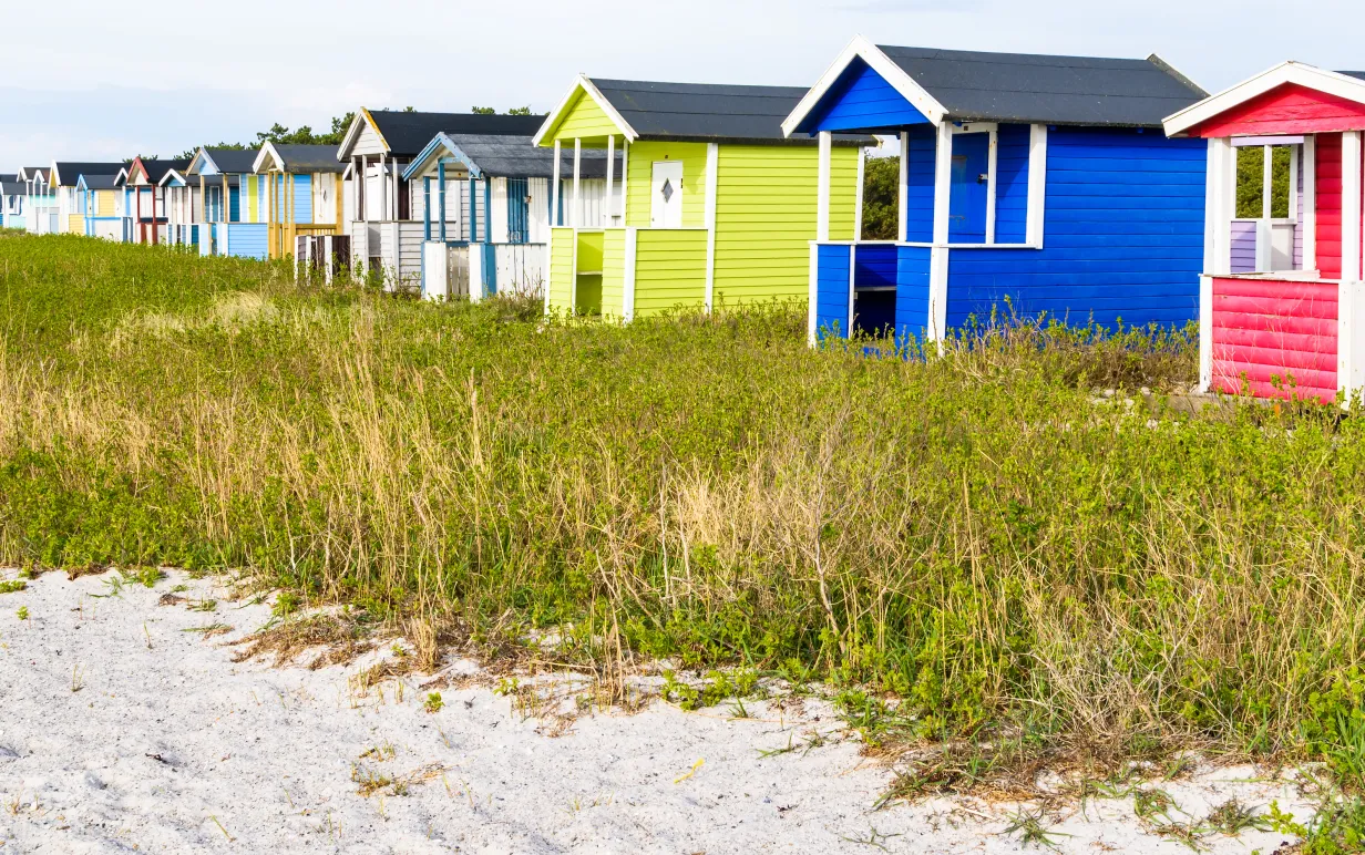 Bild på små färgglada hus i Skånevid stranden