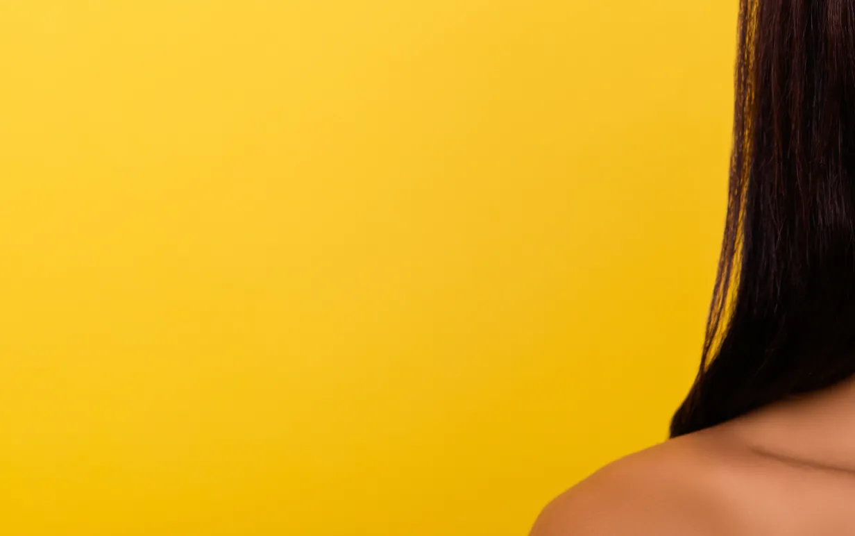 Gul bakgrund med en persons halva ansikte och axel