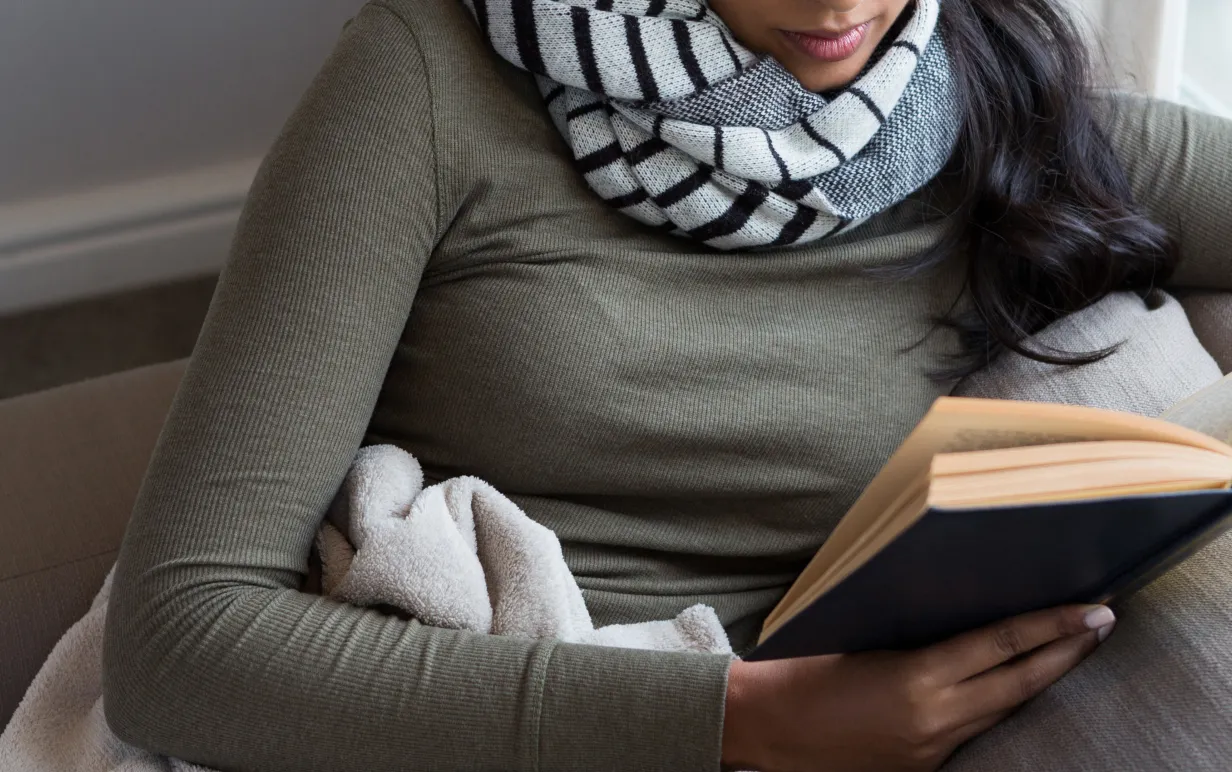 person sitter i soffa och läser