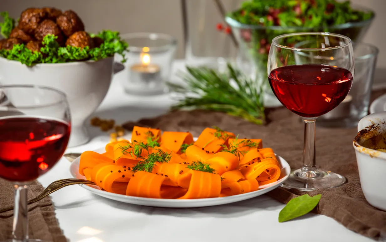 Gravad morot på en vit tallrik på ett dukat bord