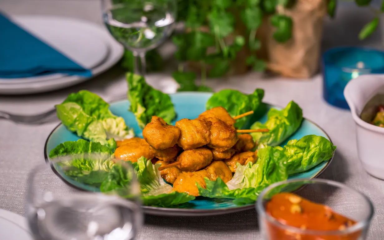 Tzayspett ligger på salladsblad på ett dukat bord