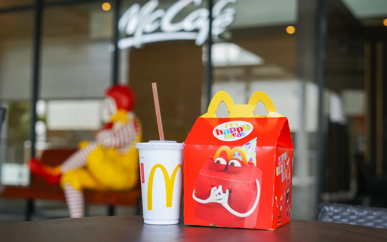 Bild på &quot;Happy Meal&quot; låda på ett bord med en mugg bredvid