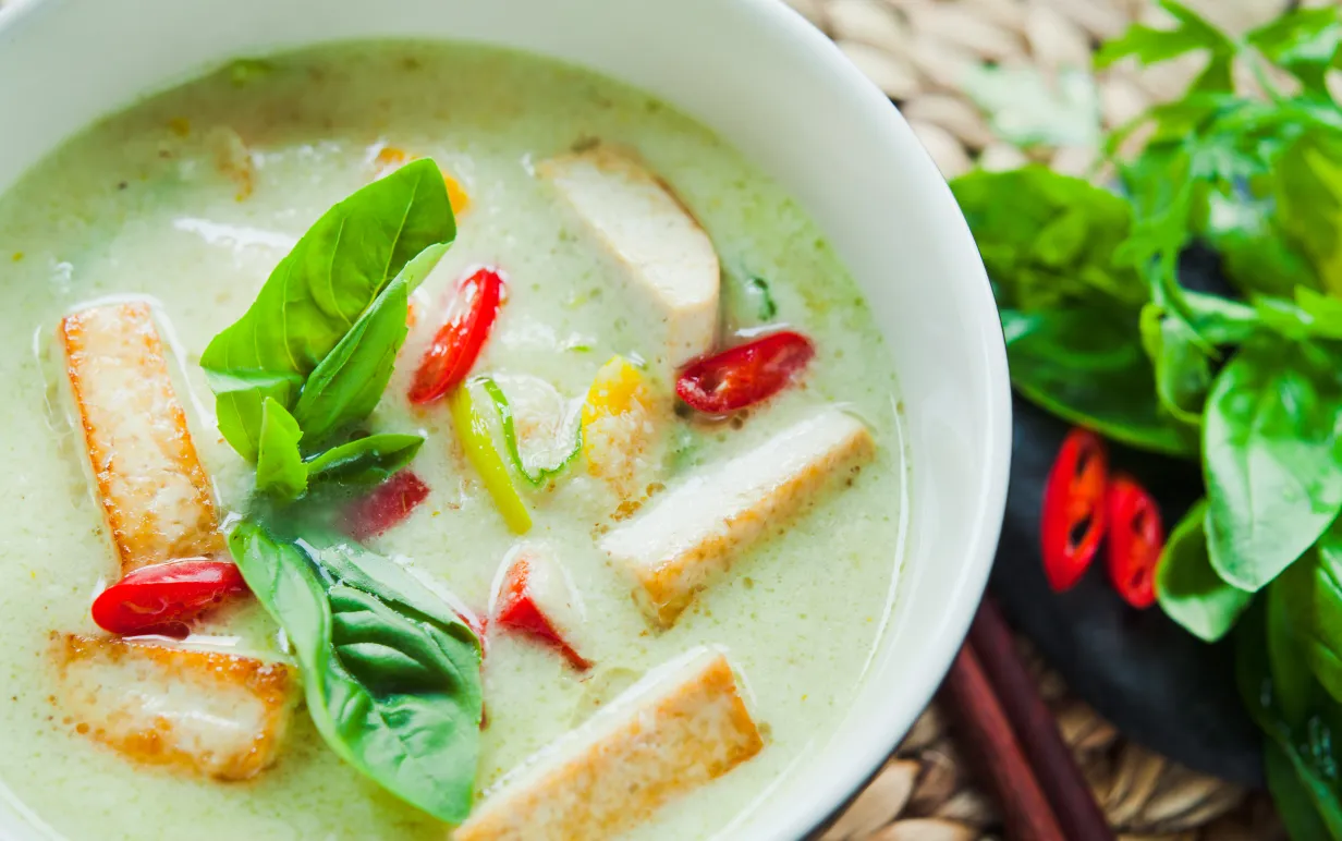 Skål med gröncurrysås och tofu.
