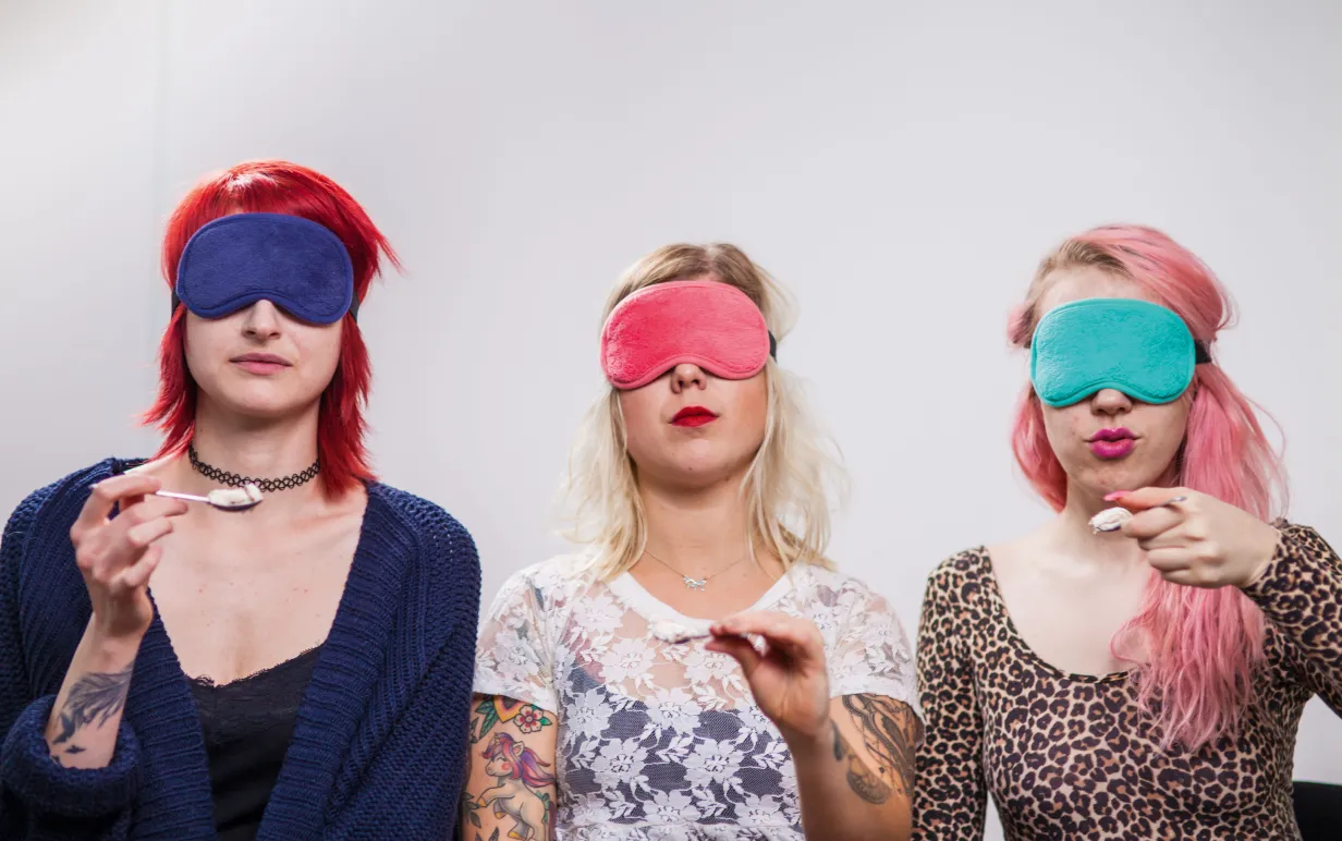 Tre personer sitter med ögonbindel och varsin sked glass.