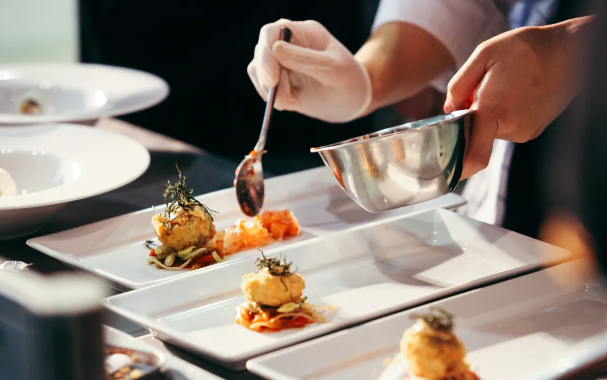 Händer lägger upp mat i en rektangulär tallrik