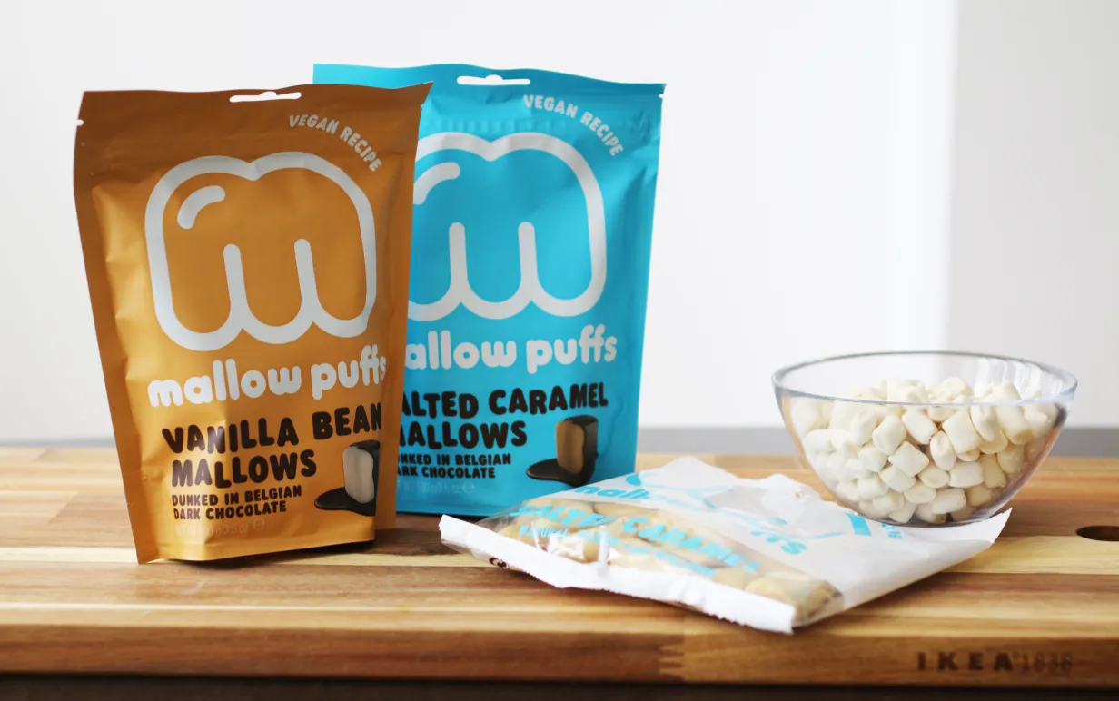 Förpackningar med veganska marshmallows på en skärbräda.