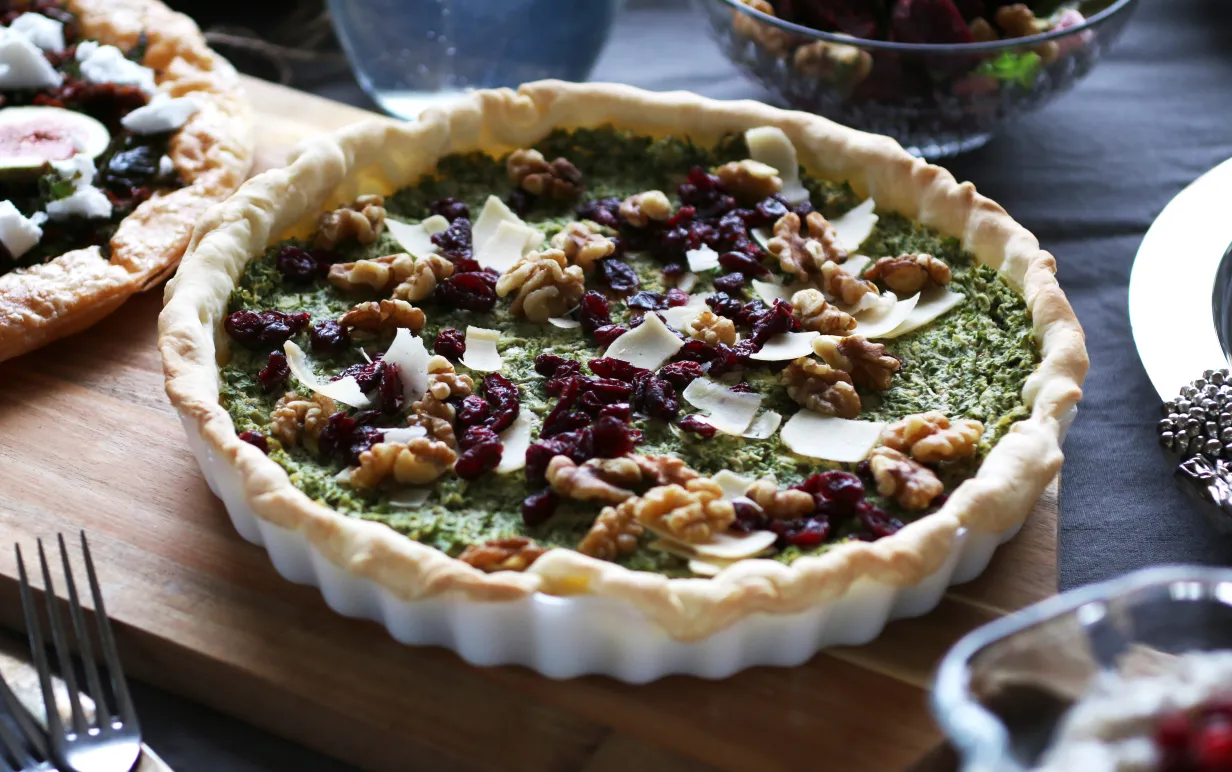 Vegansk grönkålspaj med vegansk parmesan på ett bord