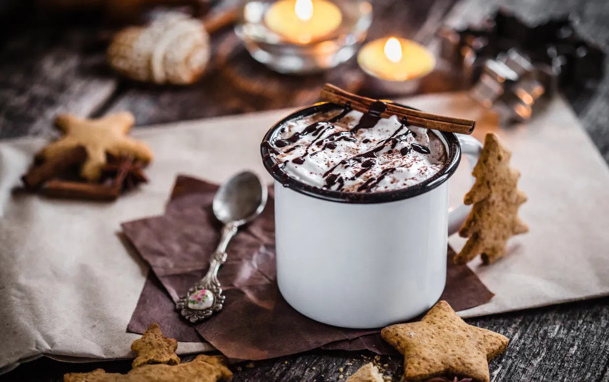 Vegansk varm choklad på ett bord omringad av pepparkakor