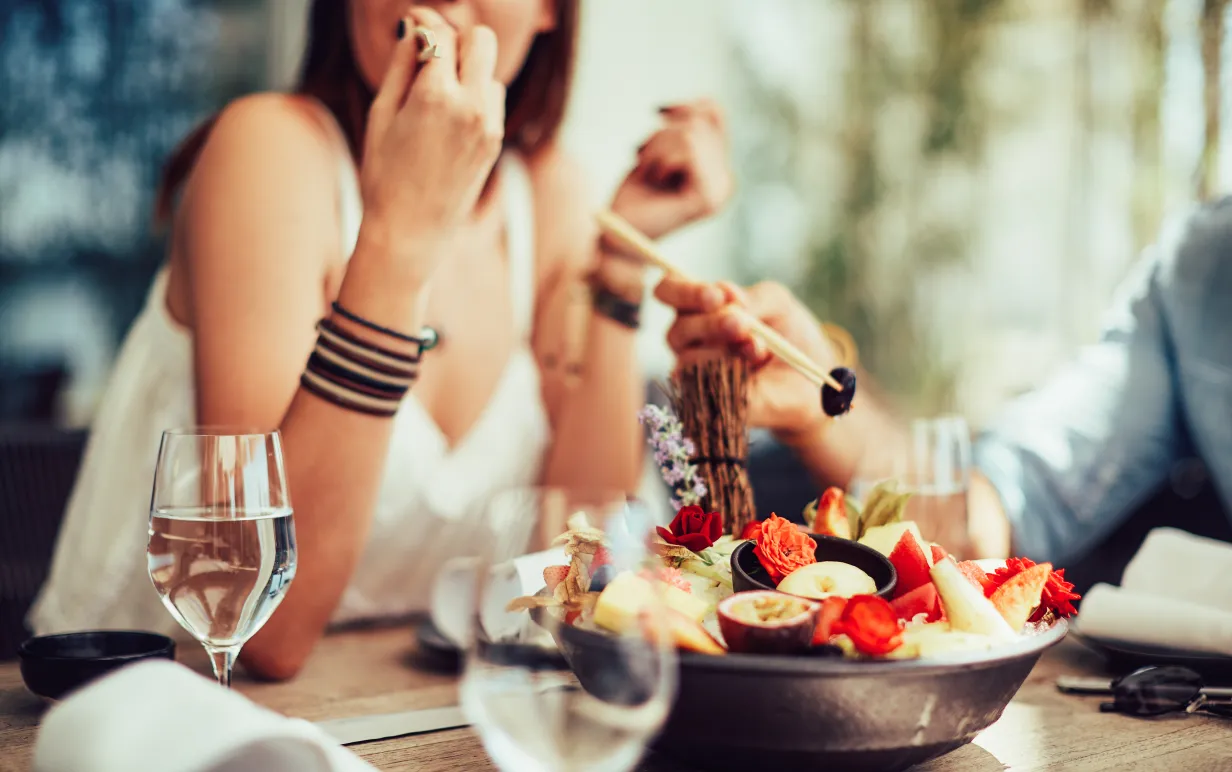 Personer sitter och äter en vegansk måltid tillsammans med andra