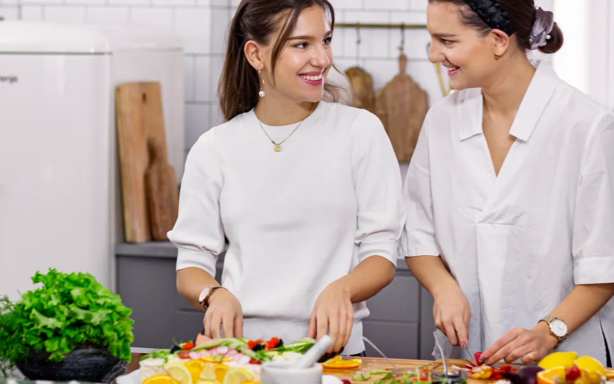 Emma och Amelia från Vegansk Matlåda står och lagar mat i ett kök