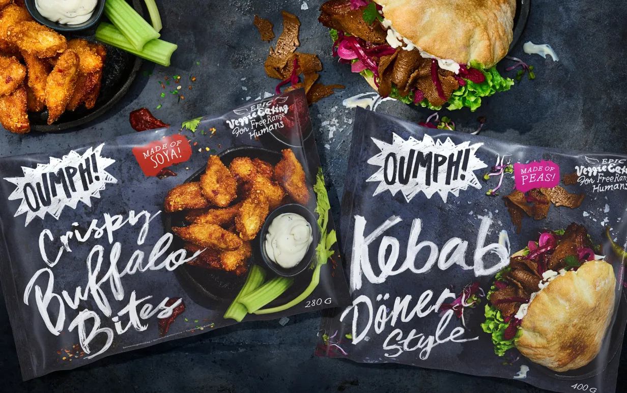 Två förpackningar med Oumph! Crispy Buffalo Bites samt Oumph! Kebab Döner Style. Vid sidan av finns produkterna upplaga för servering.