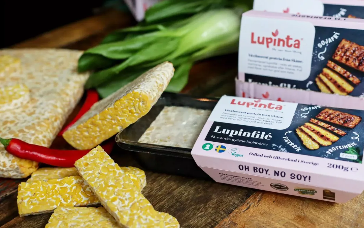 Lupinfilé från Lupinta, både i- och utanför förpackning, på bänk med grönsaker.