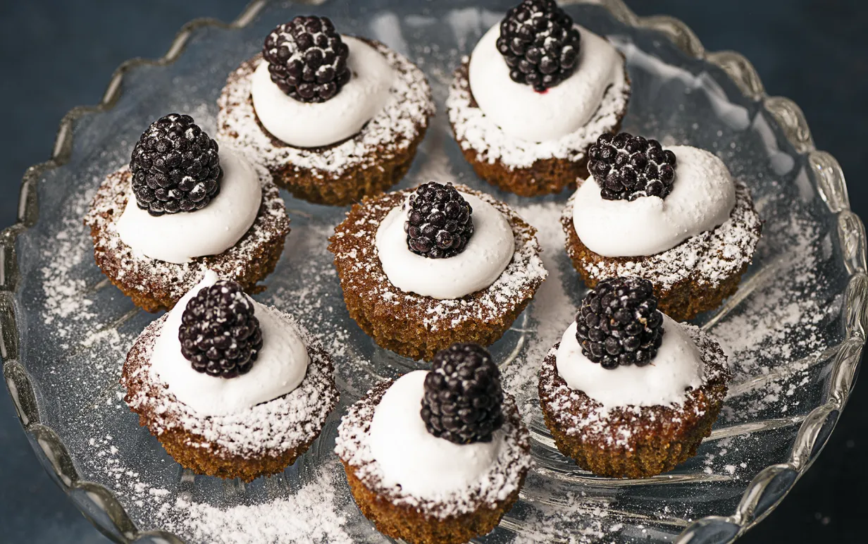 Minijulmuffins garnerade med grädde, björnbär och florsocker.