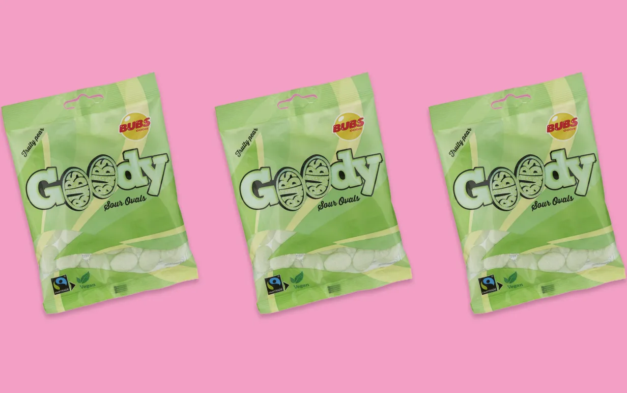 Tre gröna godispåsar uppradade mot en rosa bakgrund.