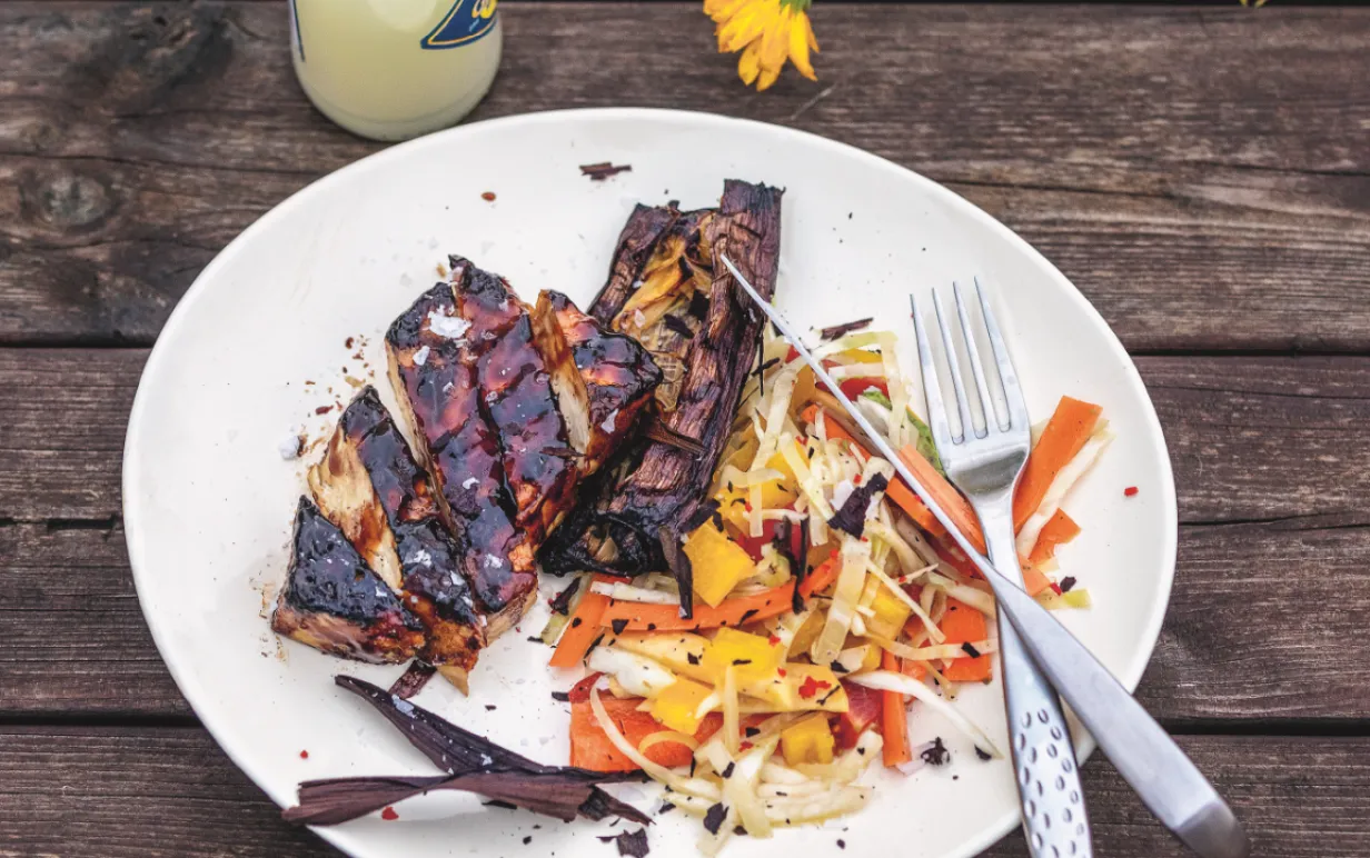 Grillad sticky tofu upplagt på en tallrik tillsammans med rivna rotfrukter.