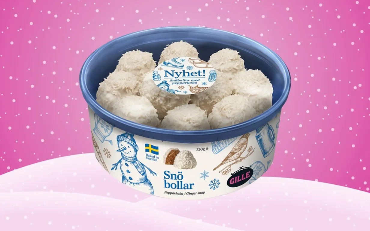 En burk med gillekakor mot en ljusrosa bakgrund med snö och snöflingor