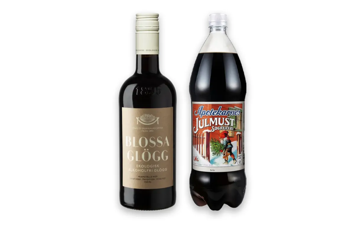En flaska glögg och en flska julmust uppställda mot en vit bakgrund