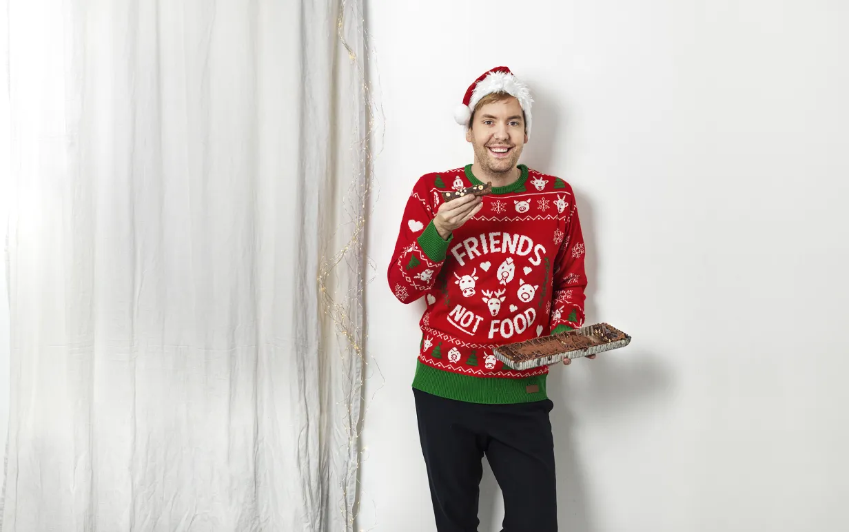 Man i jultröja mot en vit bakgrund