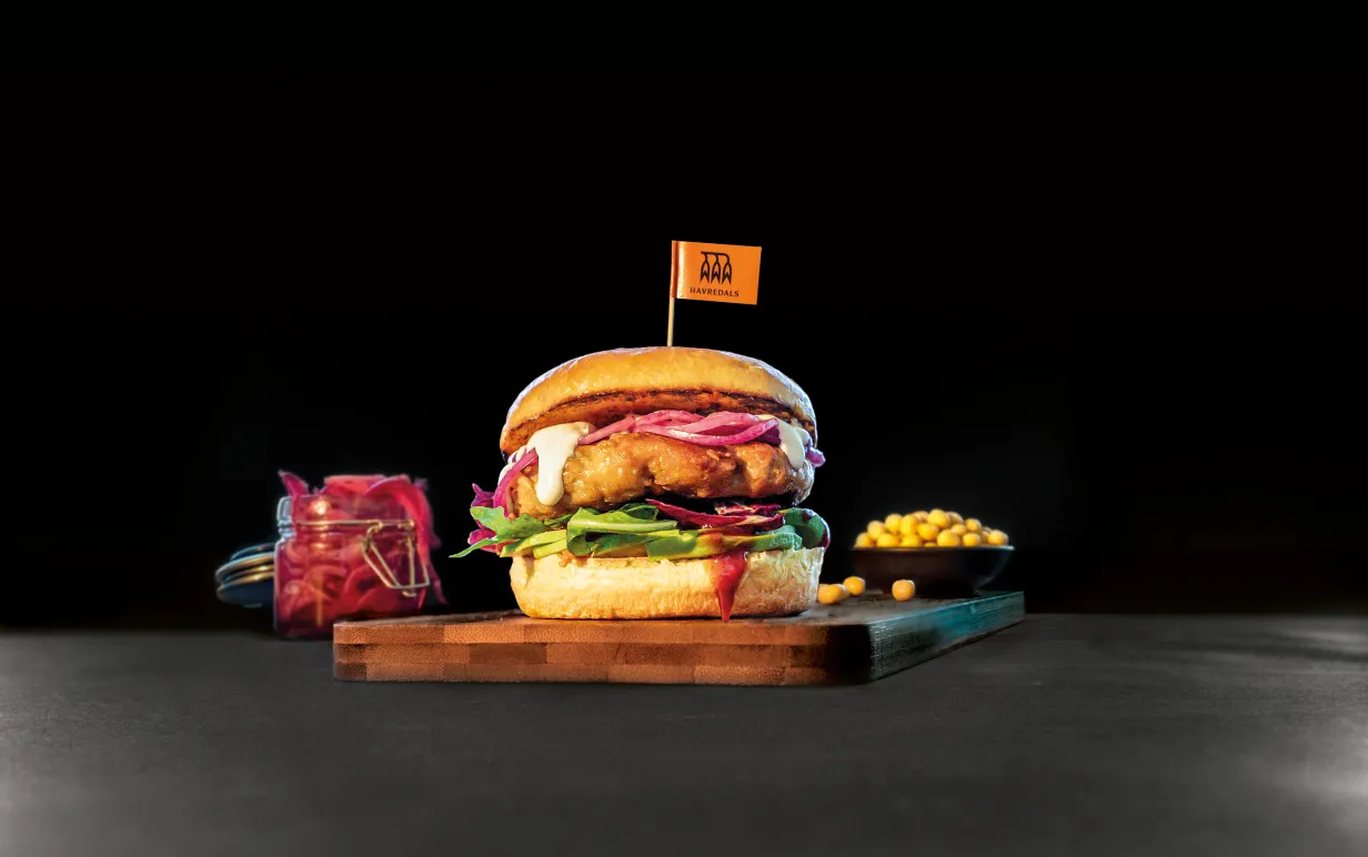 En Växtbaserad kycklingburgare mot en svart bakgrund.