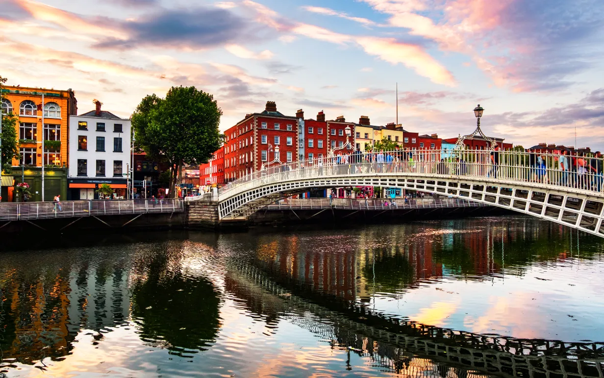 Dublin, Irland. Nattutsikt över berömda upplysta Ha Penny Bridge i Dublin, Irland vid solnedgången.