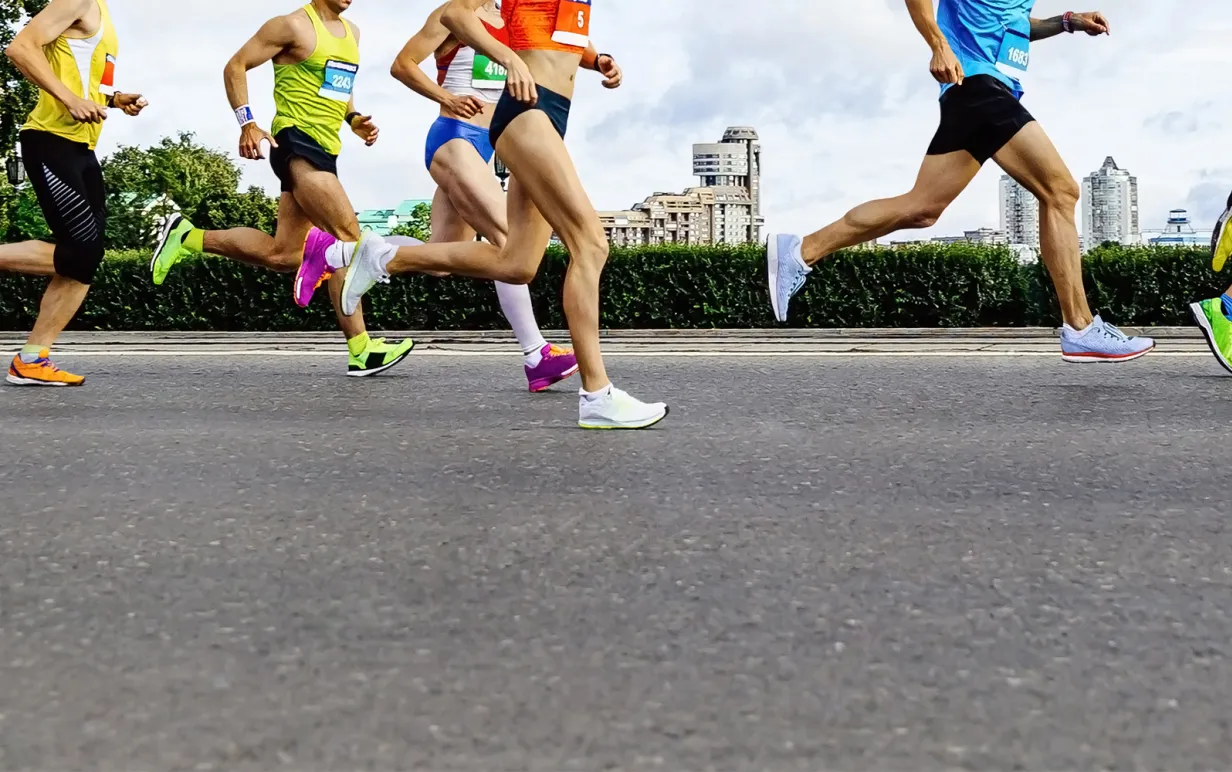 grupp idrottare löpare: män och kvinnor springer stadsmaraton i bakgrunden av byggnader