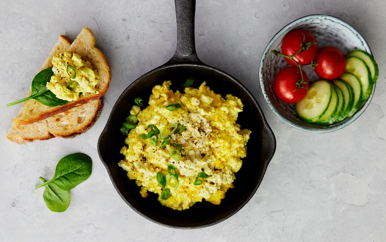 En gjutjärnspanna med tofuscramble i, bild tagen uppifrån