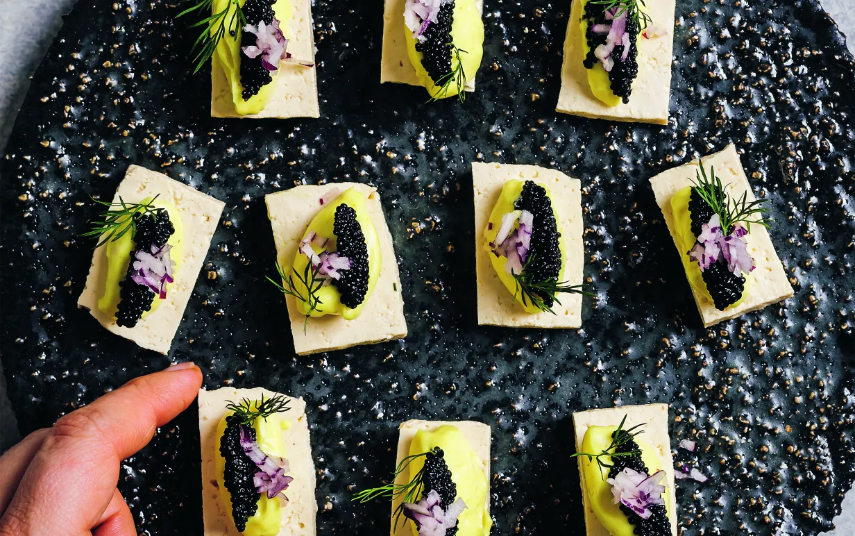 Små uppskurna tofurektanglar med majonnäs och tångrom på ett svart fat