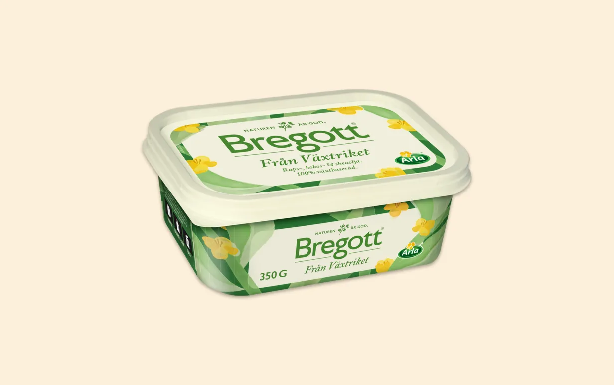 En bytta med växtbaserat smör mot en ljusgul bakgrund