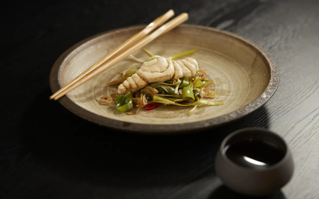 3D printad fiskfilé i en maträtt på en tallrik med ätpinnar på sida