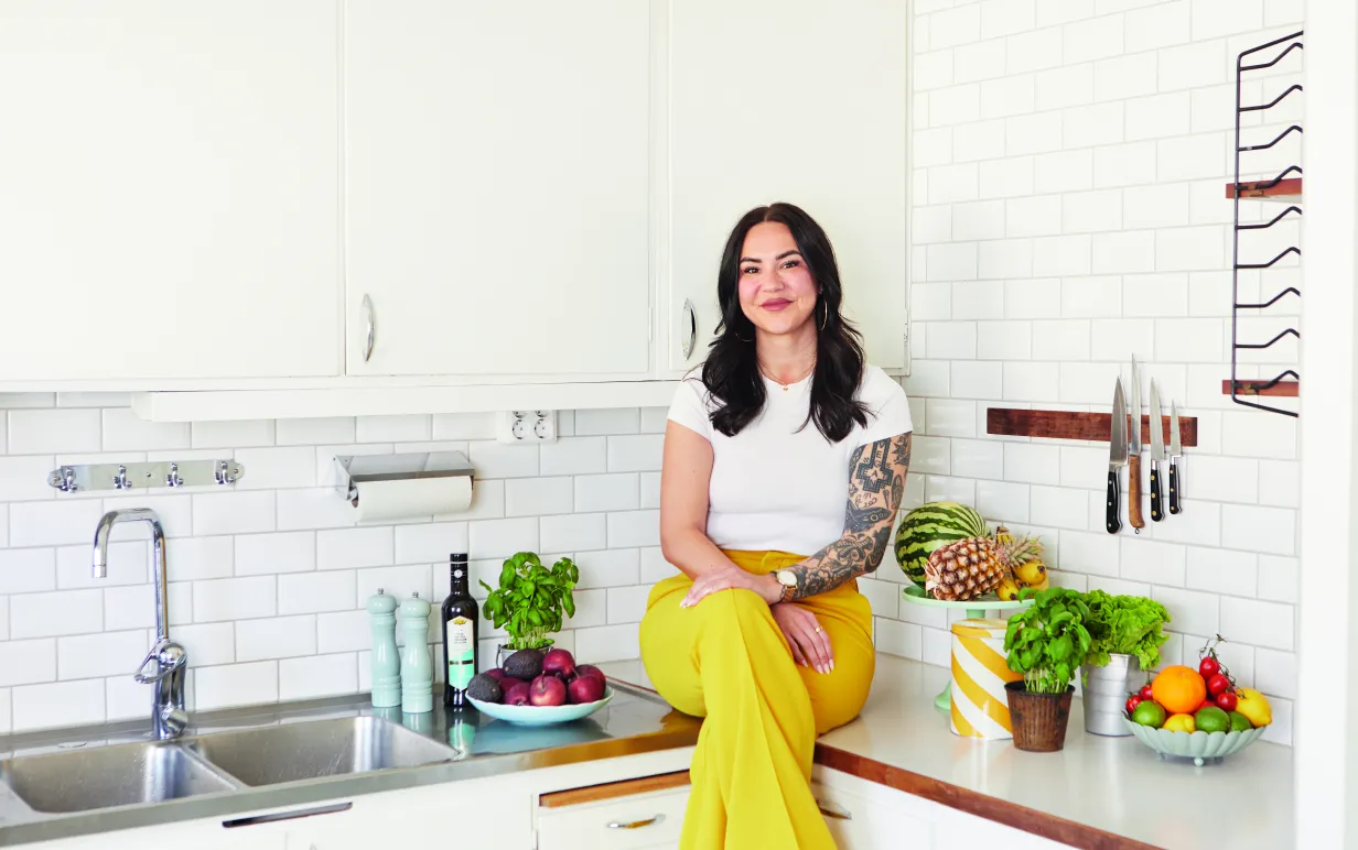 En kvinna som sitter på en köksbänk i ljusa färger