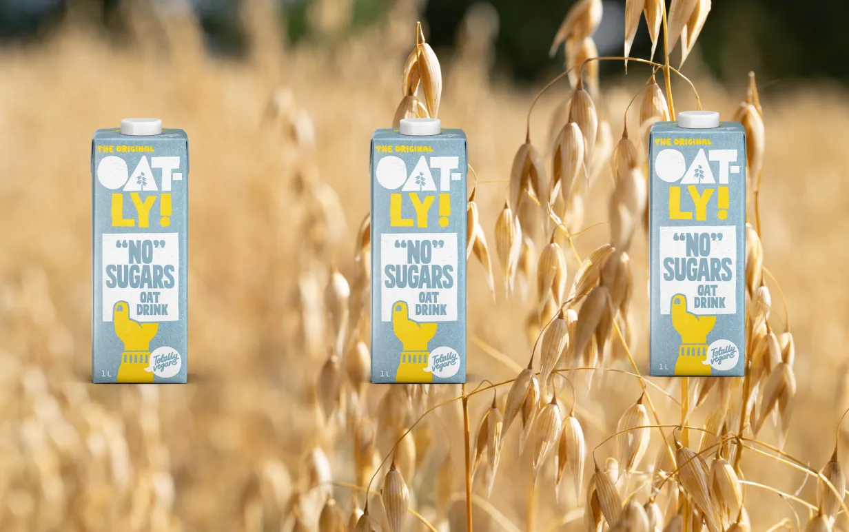 tre förpackningar havredryck mot en bakgrund som är ett havrefält