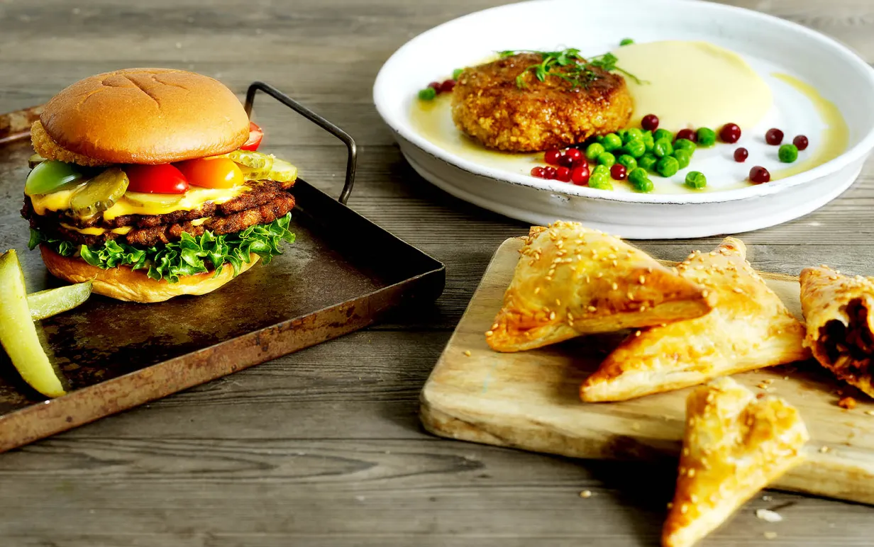 Burgare, biff med potatismos och snittar, alla gjorda på formbar baljväxtfärs, uppdukade bredvid varandra.