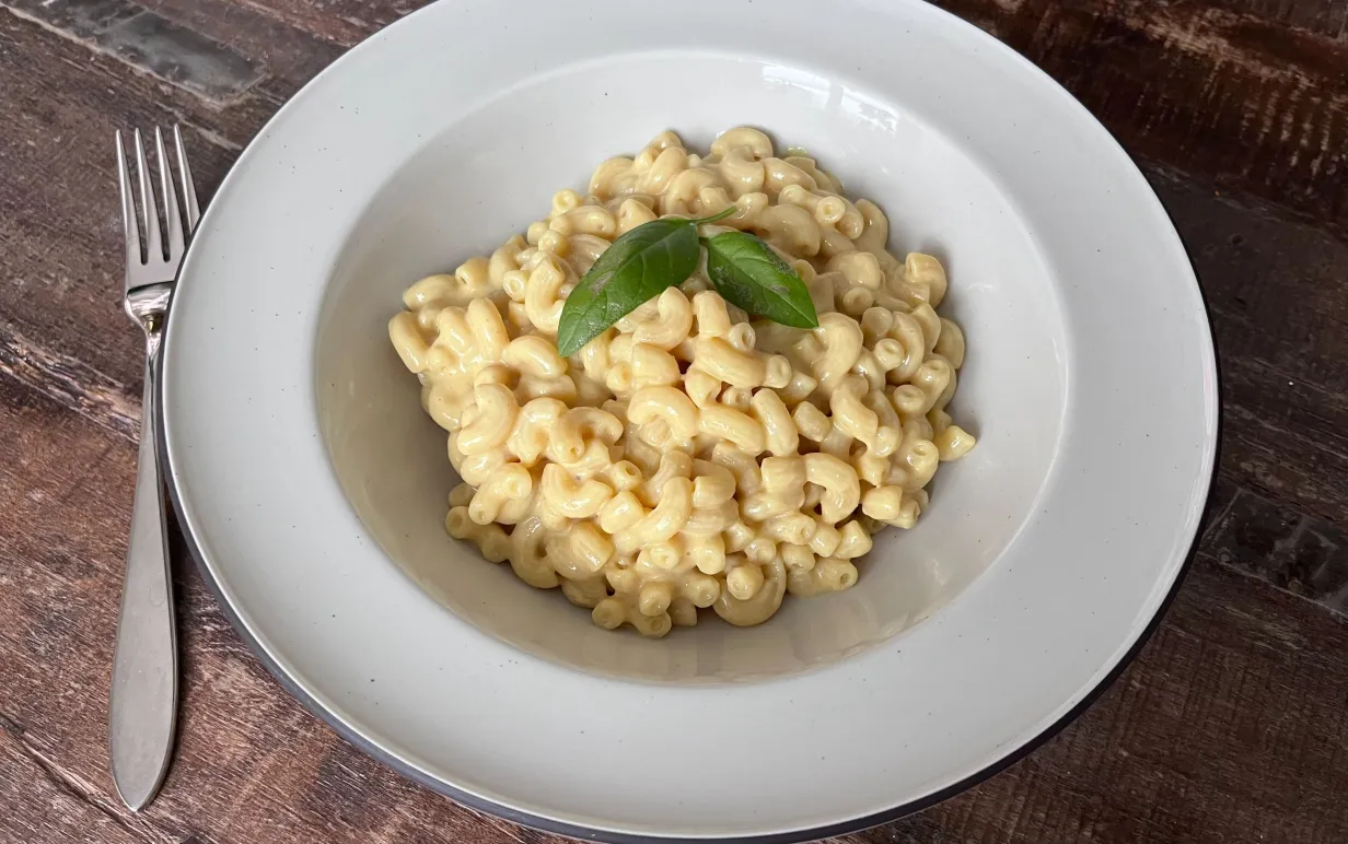 En tallrik med pasta på ett träbord.