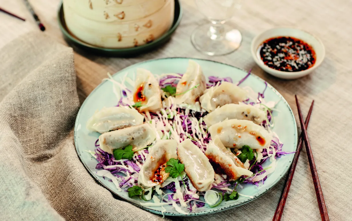 Gyozaz på ett fat med en dipp på sidan