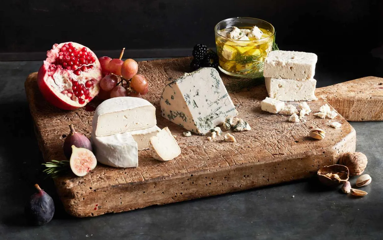 Flera olika veganska ostar på en skärbräda.