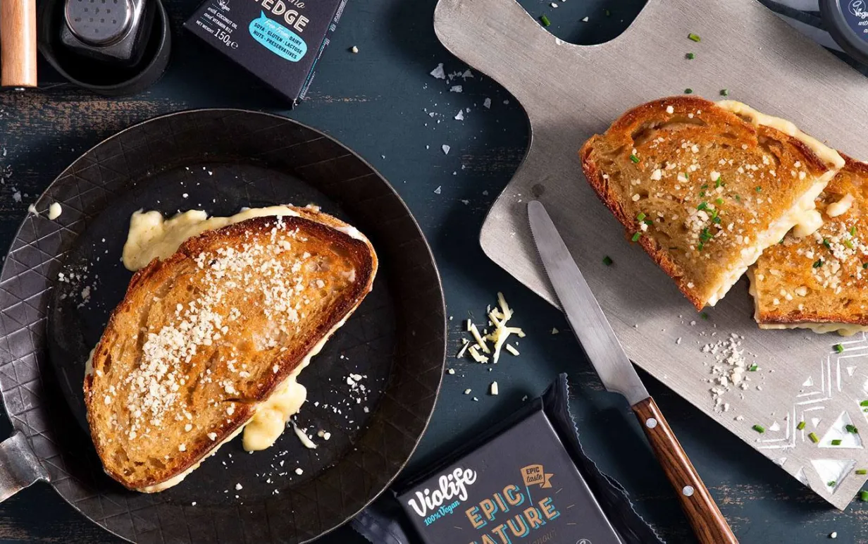 Vegansk toast i en stekpanna och en på en skärbräda