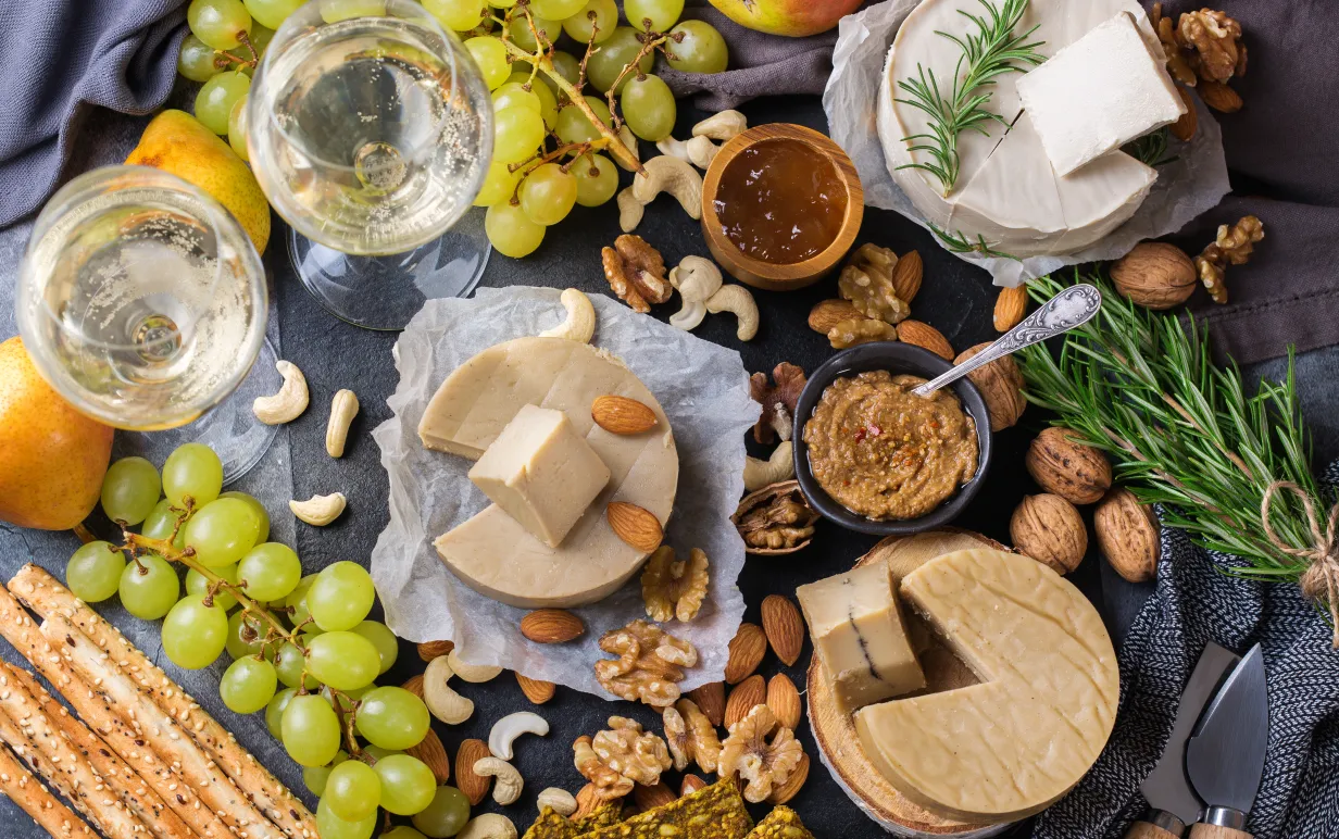 Charkfat serverad med ekologisk icke-mejerijäst råost från cashewnötter med snacks, frukt. Vegansk, vegetarisk, växtbaserad mat, näring och bantning, hälsosam kostkoncept.
