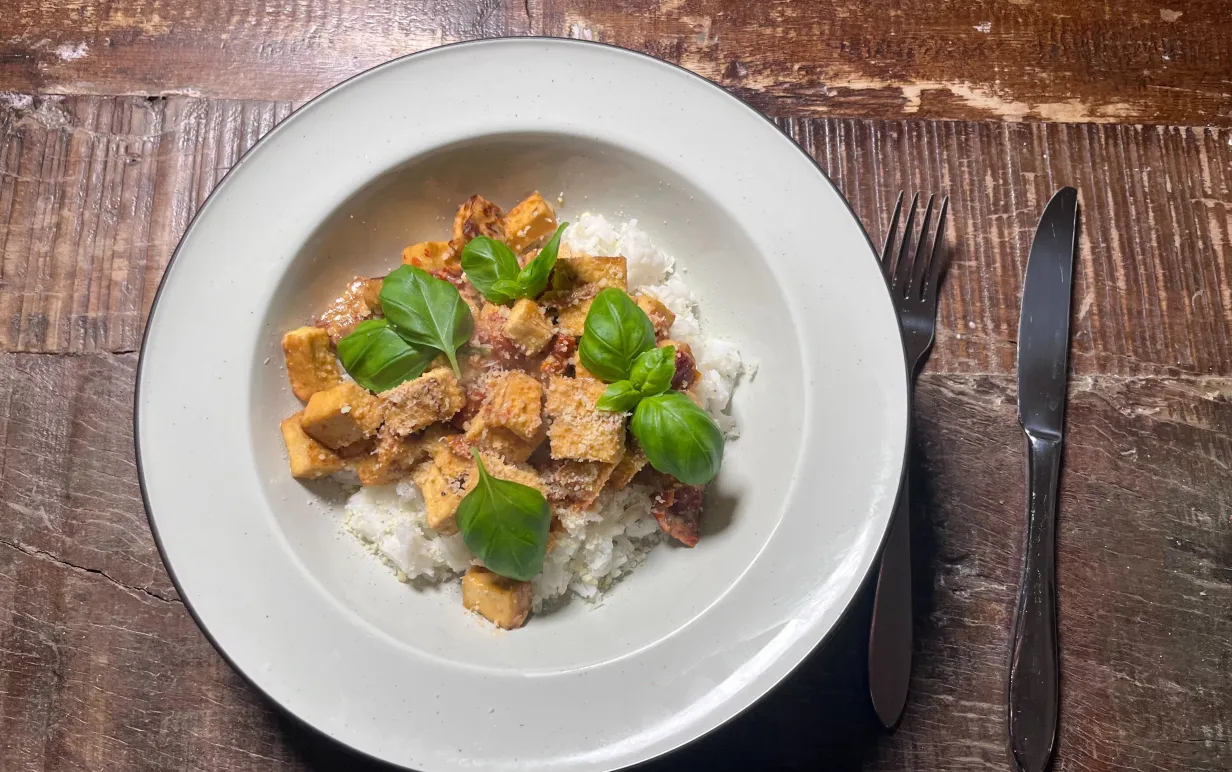 En tallrik med ris och tofu, garnerad med basilika.