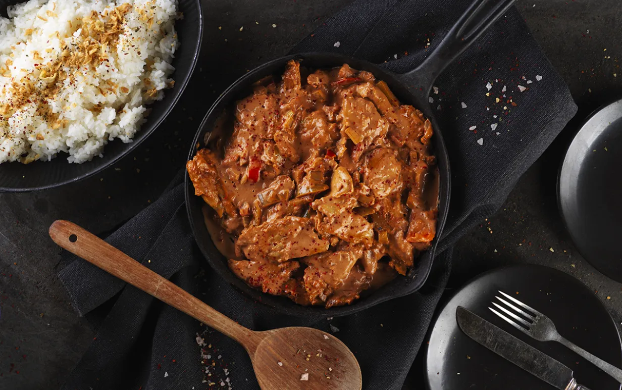 Vegansk stroganoff i en gryta på ett svart bord