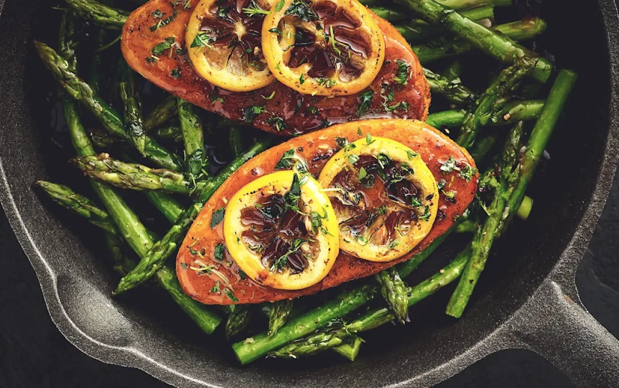 Två vegofiléer på en bädd av sparris i en stekpanna