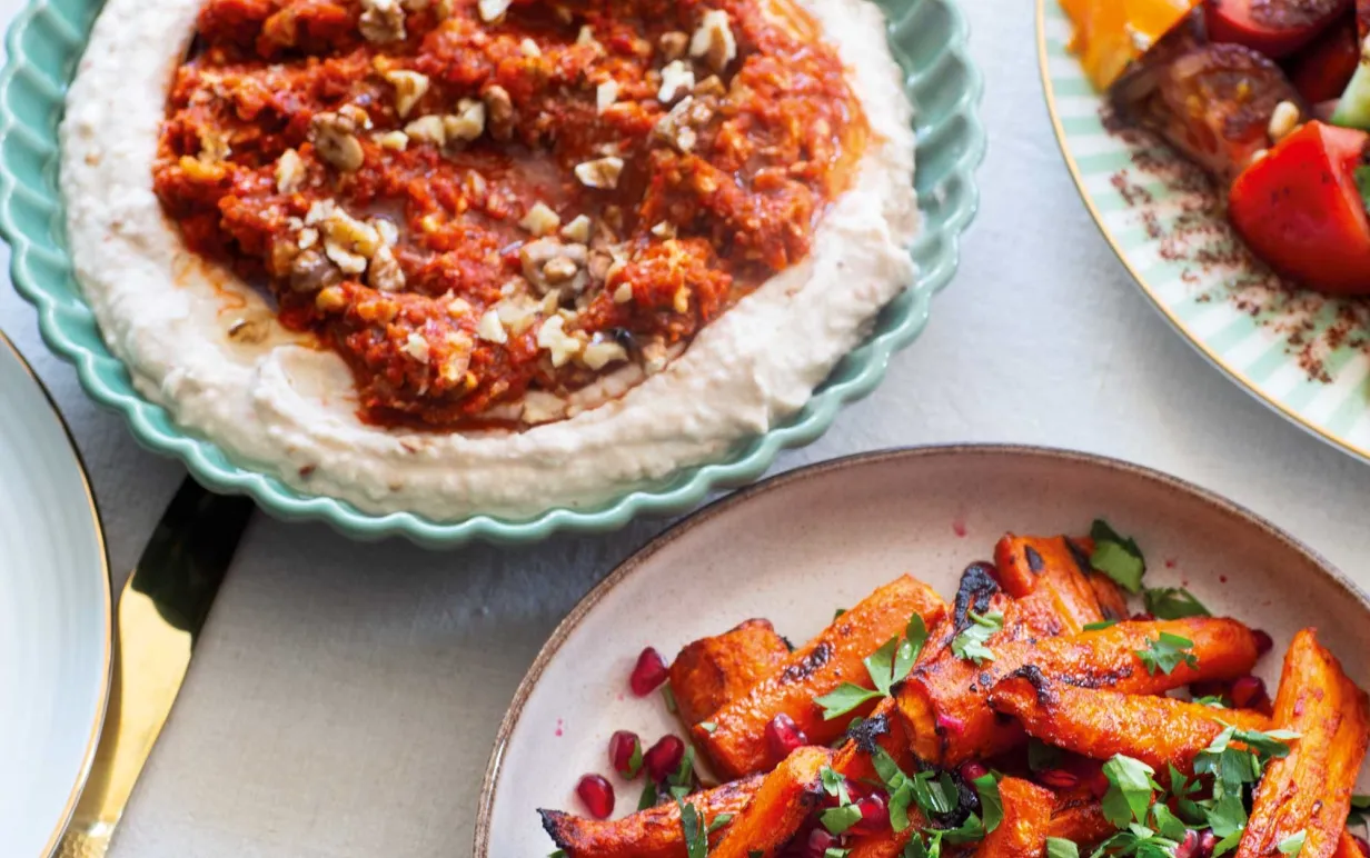 Harissarostade morötter på en tallrik bredvid en röra