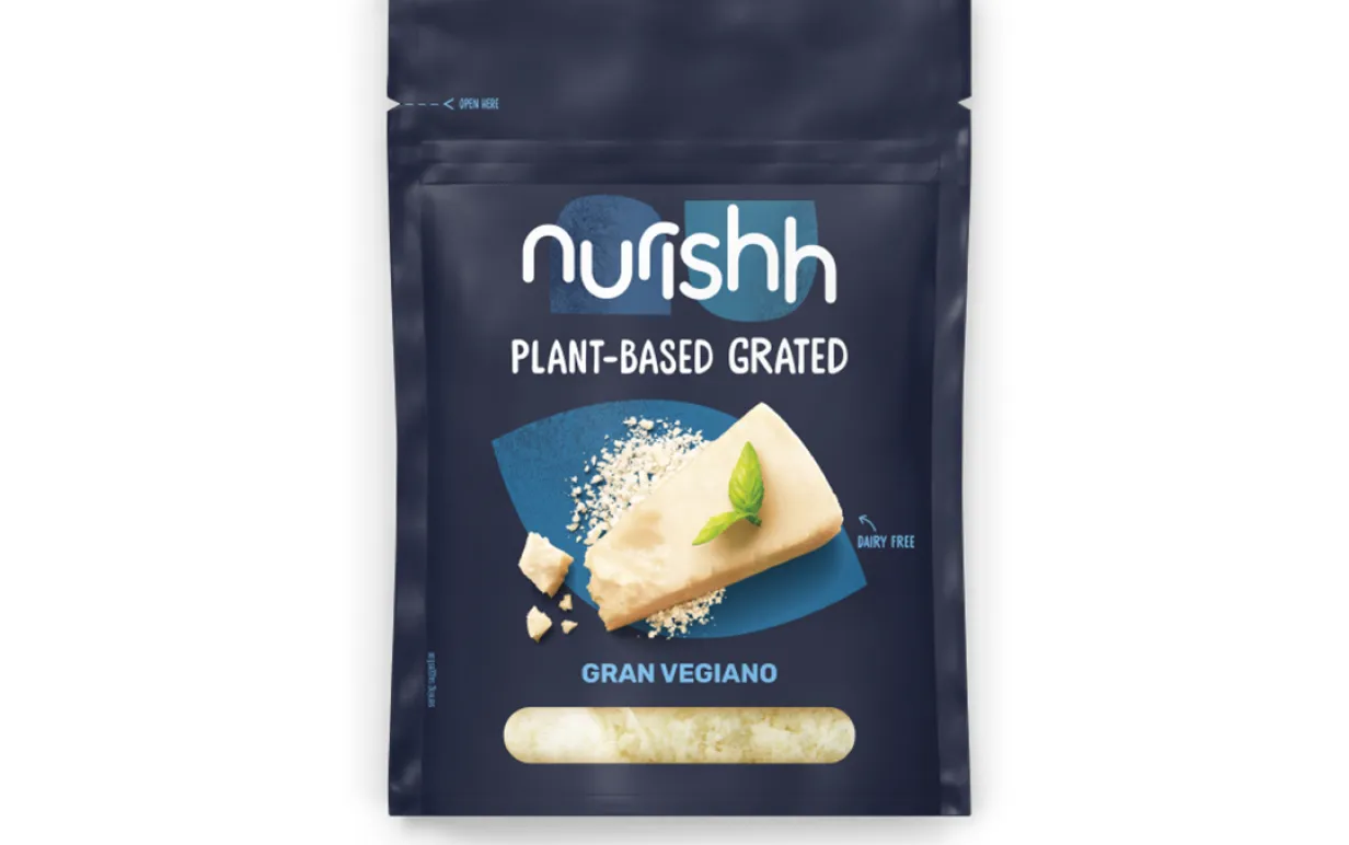 en påse riven vegansk ost mot en vit bakgrund