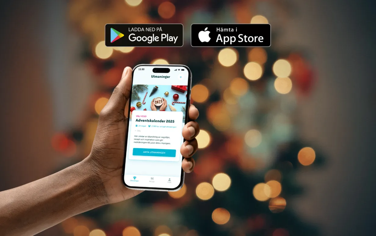 En hand som håller upp en smartphone mot en julbakgrund