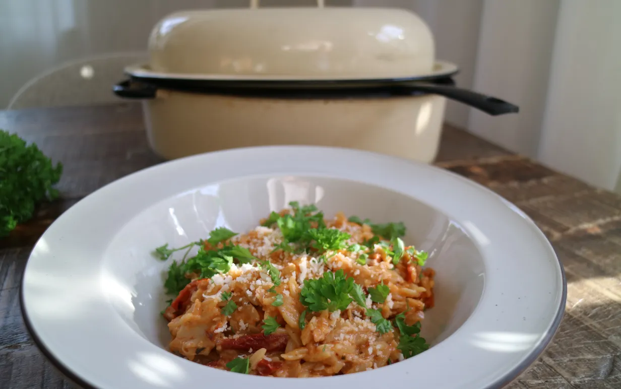 En tallrik risoni framför en gryta